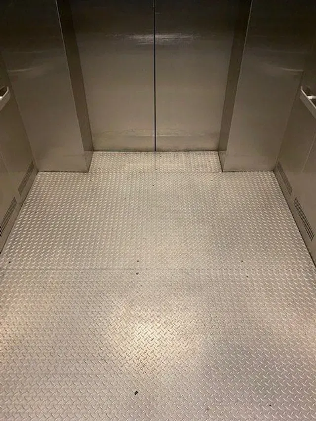 Freshly cleaned diamond-plate industrial elevator floor