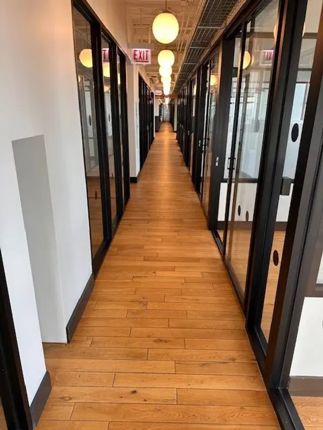Polished office corridor with glass doors and warm lighting
